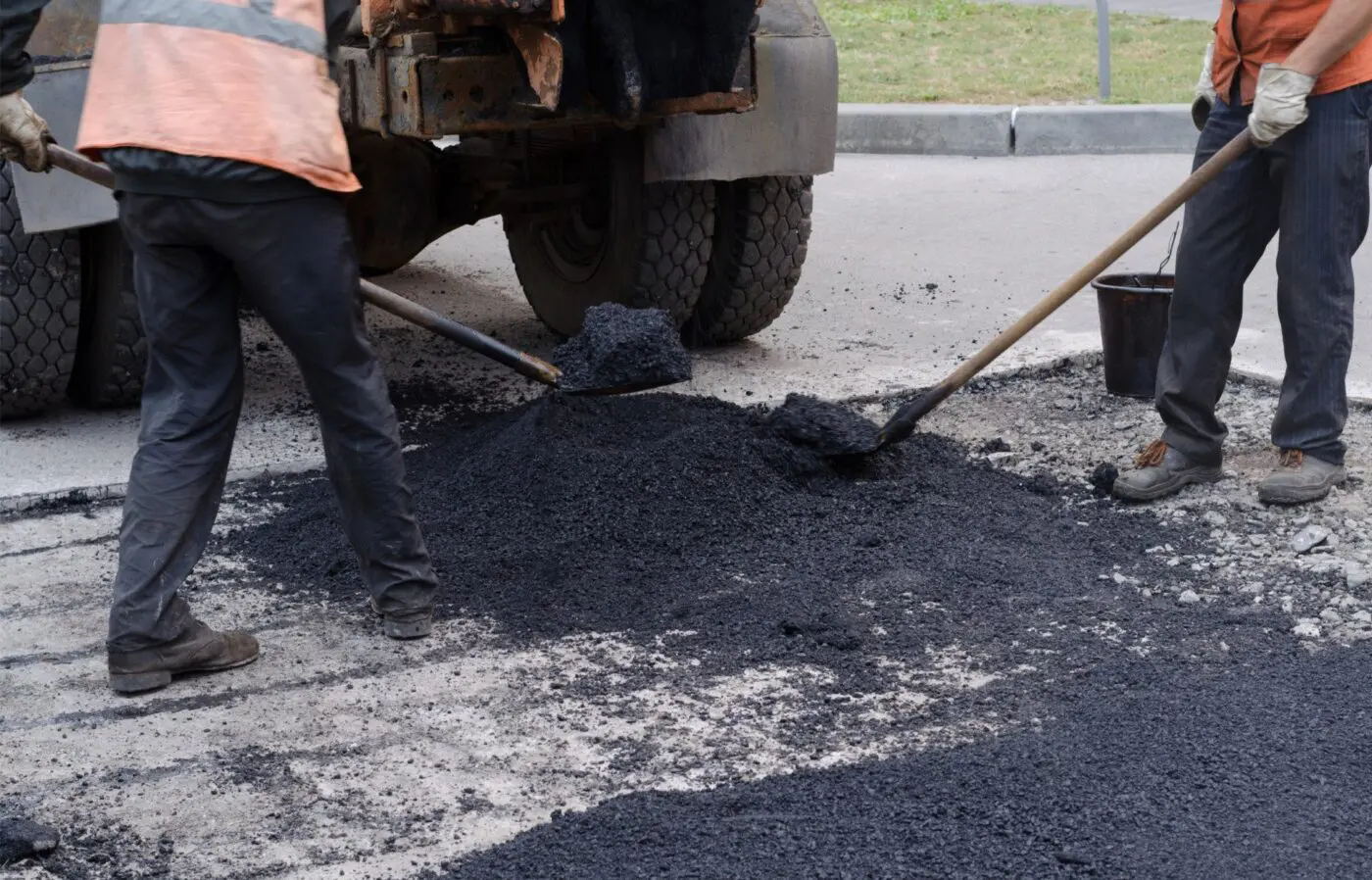 asphalt worker cutting asphalt road for a hot patch